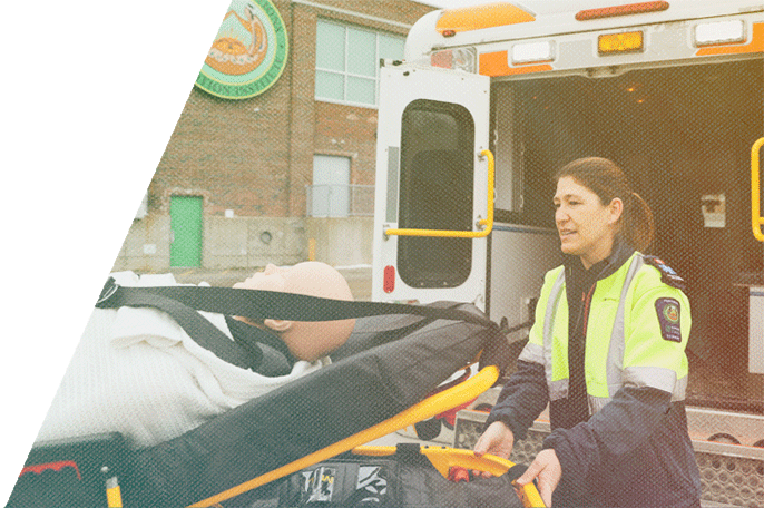 Paramedic student loading a stretcher into the back of an ambulance