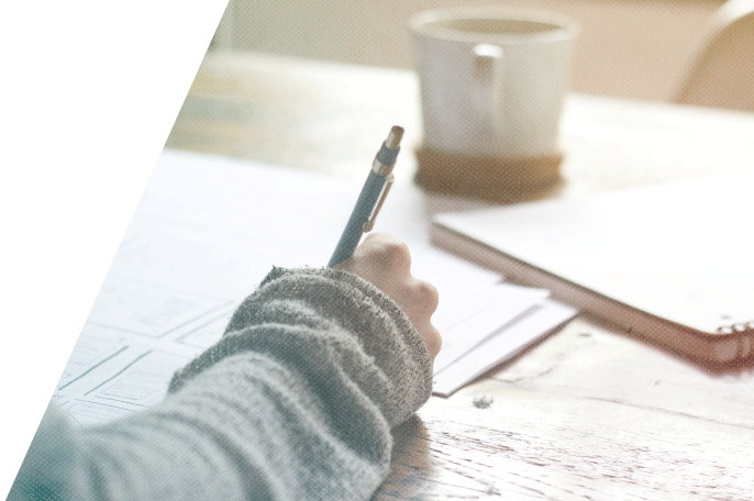 Person writing on a piece of paper with a pen