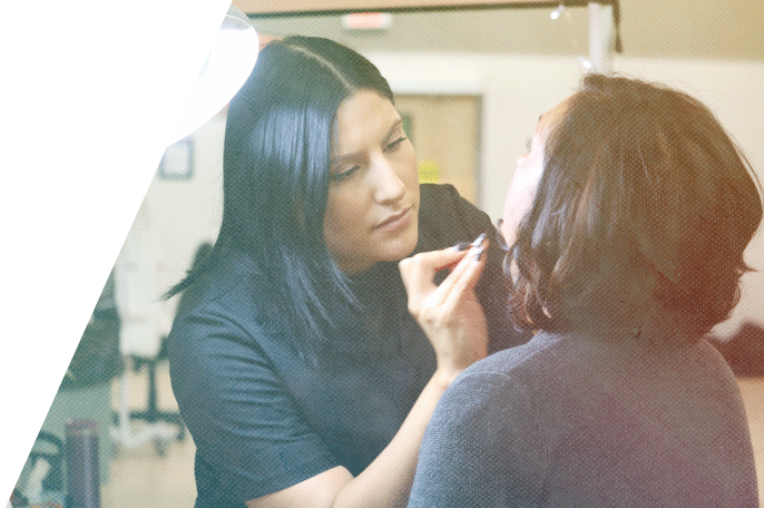 Esthetician student using tweezers on a client under a bright light