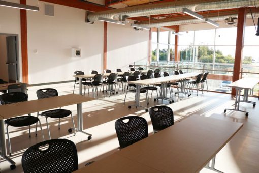 Seating area in SGEI's Fort Frances campus Mezzanine featuring long tables and chairs