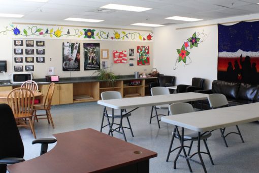 The Cultural classroom at our Kenora Campus featuring desks, chairs, a mural and hand-painted flowers on the wall