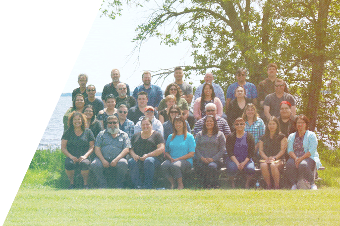 SGEI staff sitting outside in front of a lake