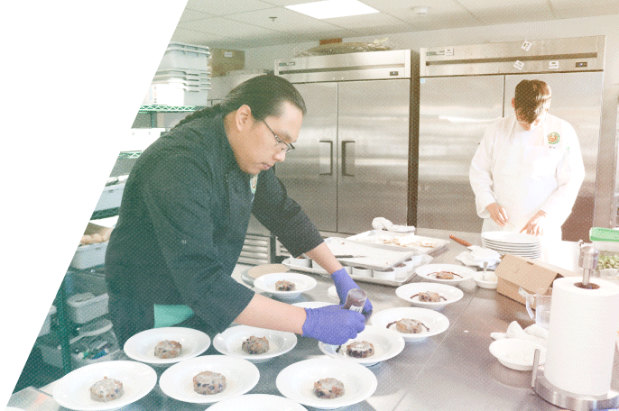 A student prepares dishes in the Culinary course