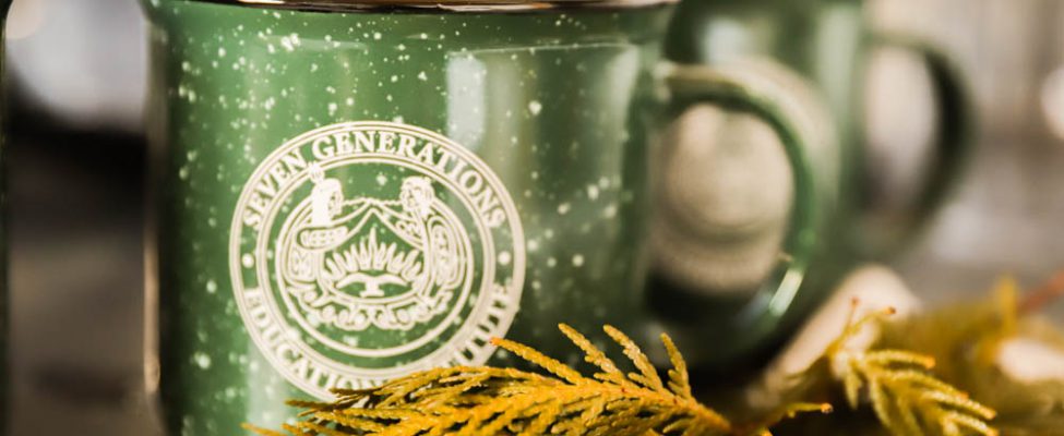 A coffee mug placed beside a bundle of fragrant cedar