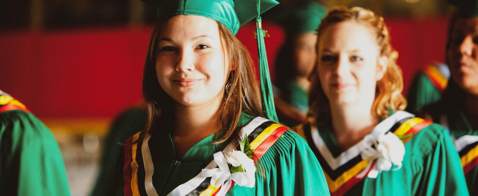 Students standing together adorned in graduation gowns