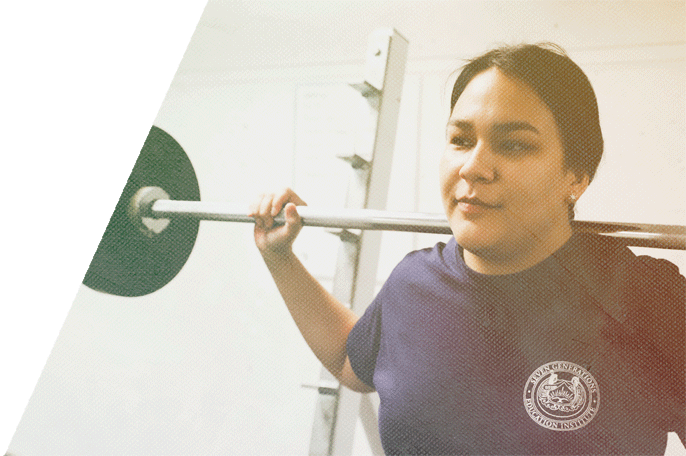 Female SGEI student lifting weights in SGEI's fitness lab