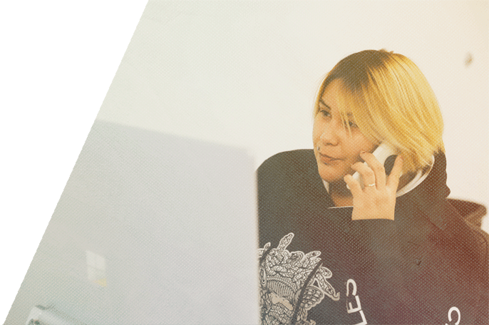 Student talking on the phone in front of a desktop computer