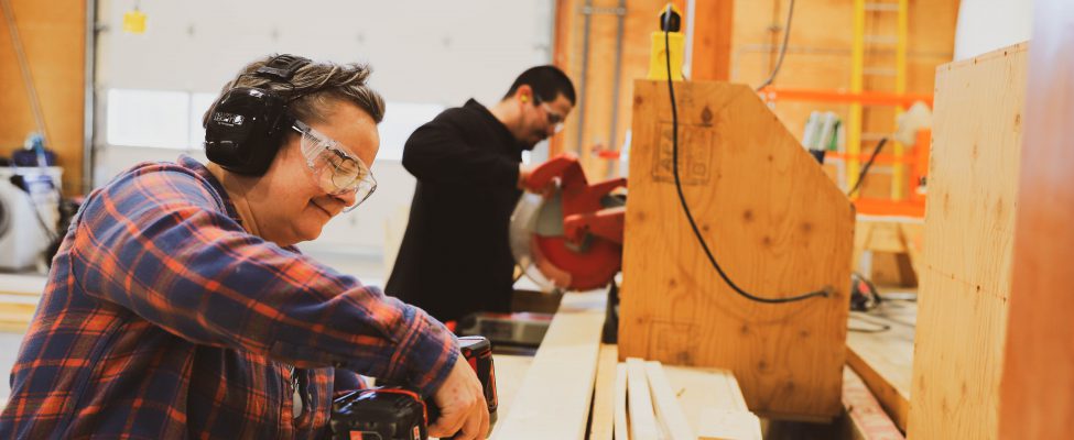 A building construction student actively engaged in hands-on construction work