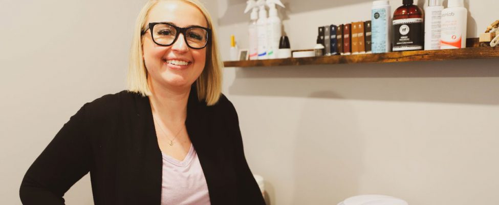 Esthetician graduate standing inside classroom