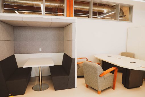 Student study cubicle next to a large study table and chairs