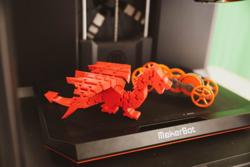 Plastic 3D model of a winged dragon sitting in a 3D printer