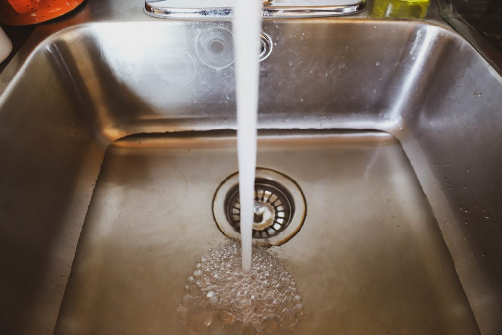 A close-up photo of a running sink with flowing water