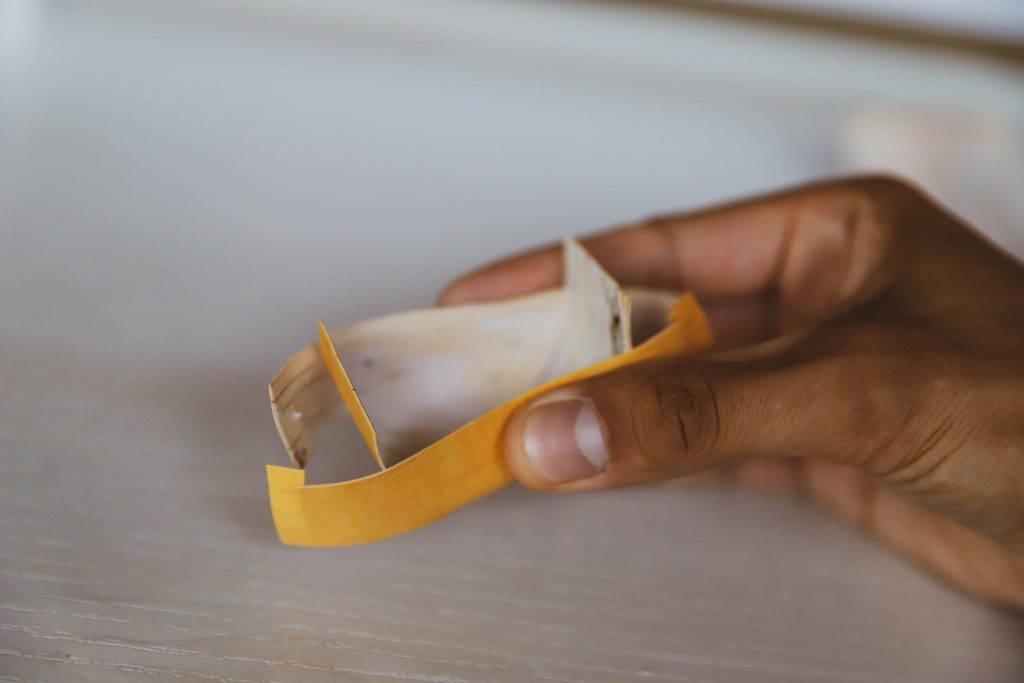 A piece of birch bark being folded into a traditional spirit dish