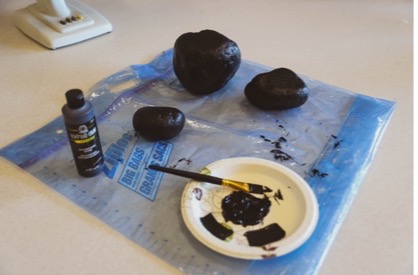 A group of rocks fully coated with black paint