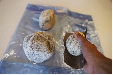 Collection of rocks being smoothed with sandpaper