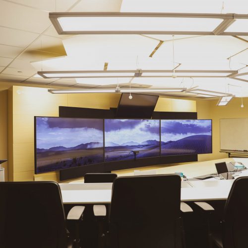 Three TV monitors at the front of the telepresence room at SGEI's Kenora campus