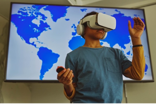 A young boy using a virtual reality (VR) headset to explore and interact with a geographical map