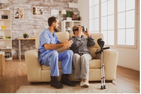 A Personal Support Worker assists a disabled woman in using a virtual reality (VR) headset