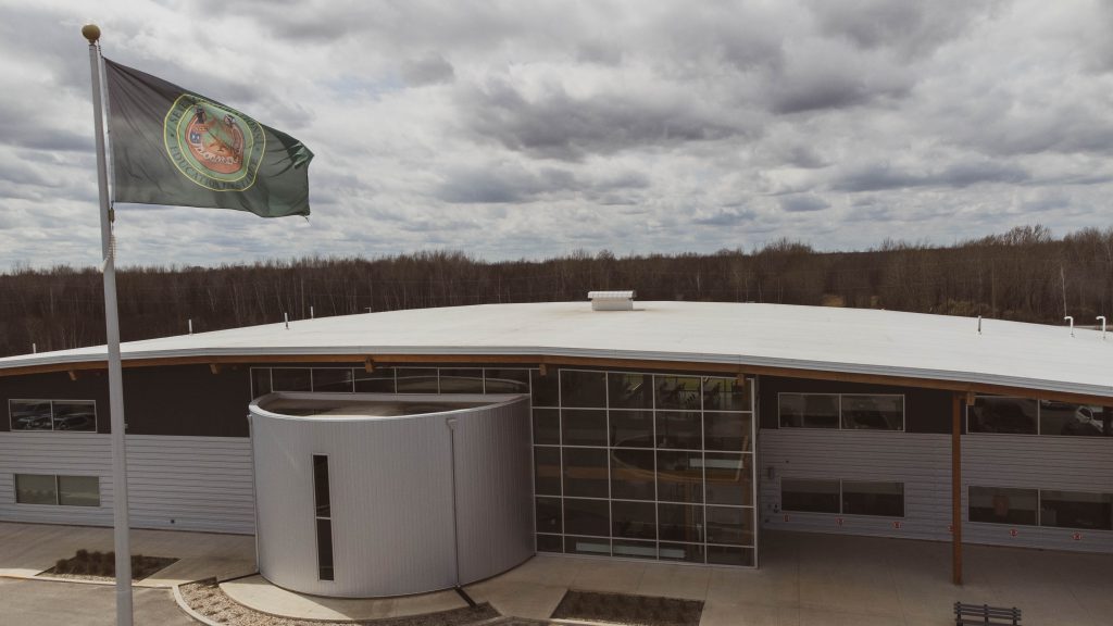 Image of a higher education building with organization flag blowing in the wind.