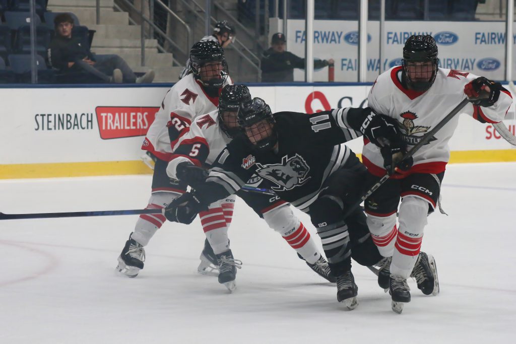 Three Kenora Thistles players converge on a Eastman Selects skater.