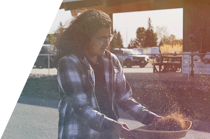 An SGEI student winnows rice.