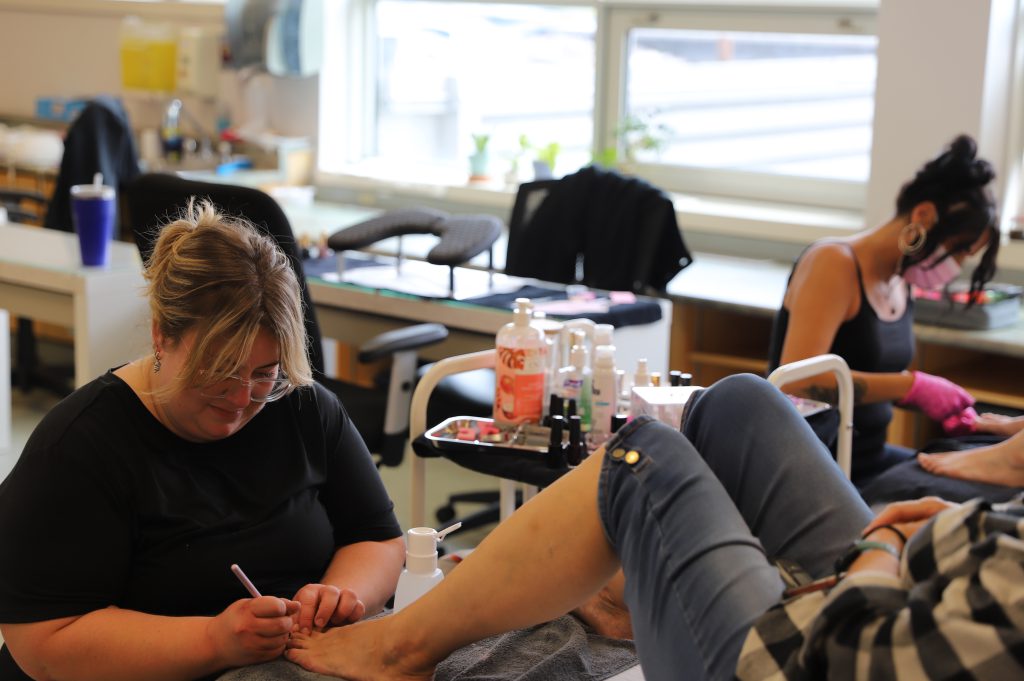 Esthetician student Amy McMahon works on a client's feet during an SGEI Spa day at the Kenora Campus.