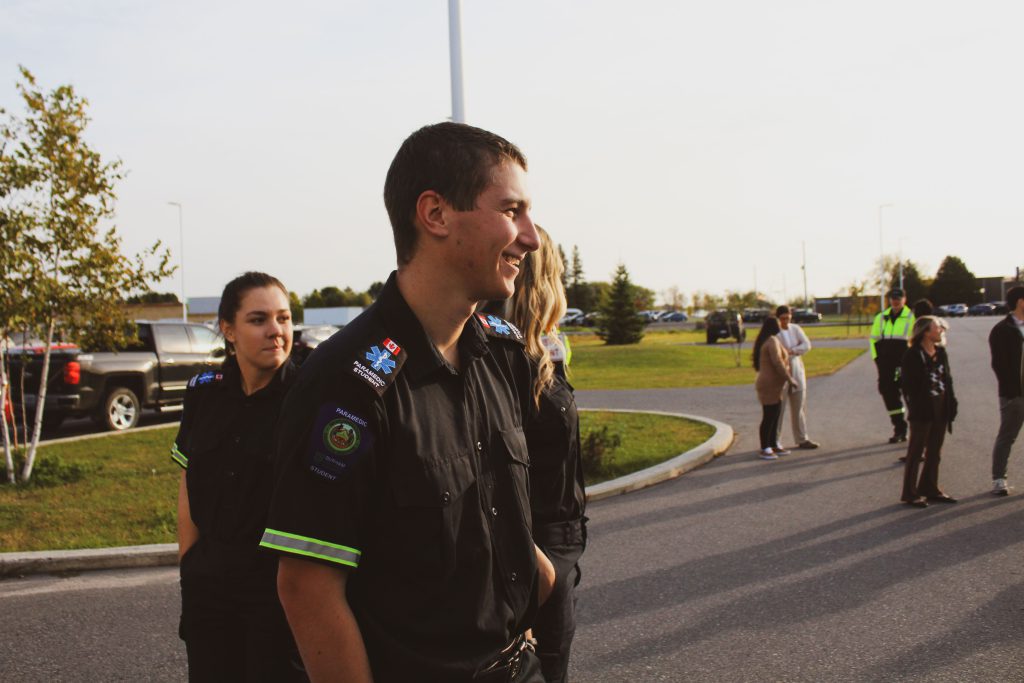 Paramedic student Fletcher Klug laughs outside SGEI's Rainy Lake Campus.