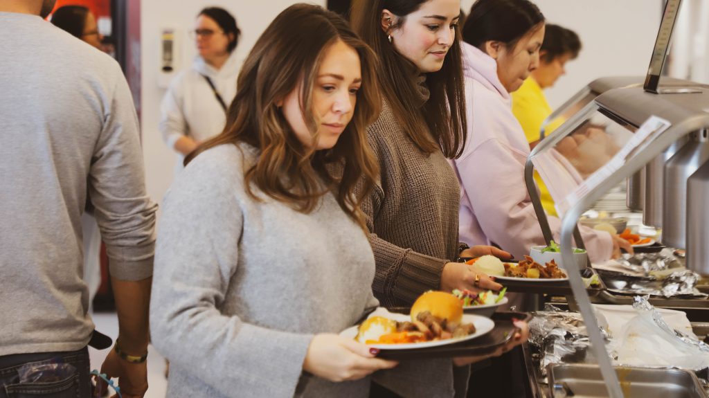 SGEI staff and students stand in line for lunch at the Rainy Lake Campus.